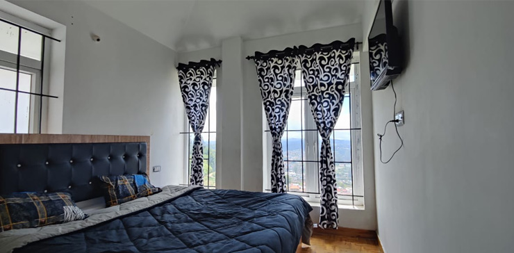 Bedroom with a wall-mounted TV and a scenic view through a large window