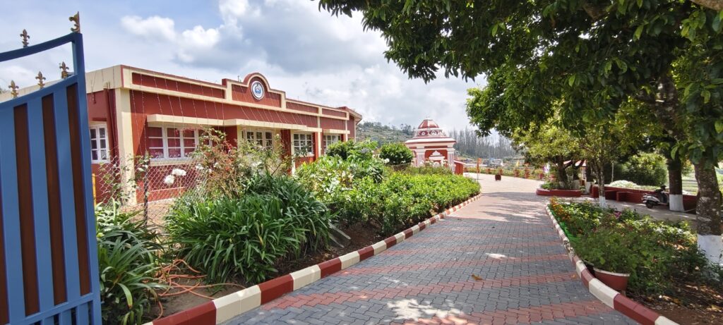 Garden pathway inside Ramakrishna Math Ooty with trees and buildings
