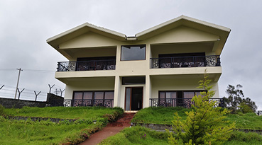 Two-story cottage with balconies amid greenery