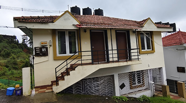 Compact cottage with tiled roof and exterior stair