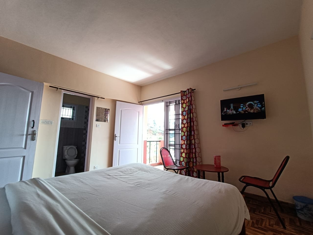 Bedroom with balcony access and sitting chairs