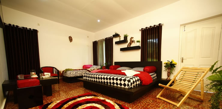 Large, well-furnished bedroom in Ooty estate cottage with modern décor and seating areaooty-cottage-cozy-bedroom-interior