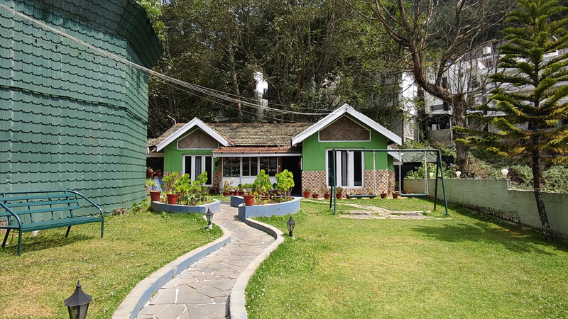 Cottage exterior view with landscaped garden, green lawn and stone walking pathway leading to entrance