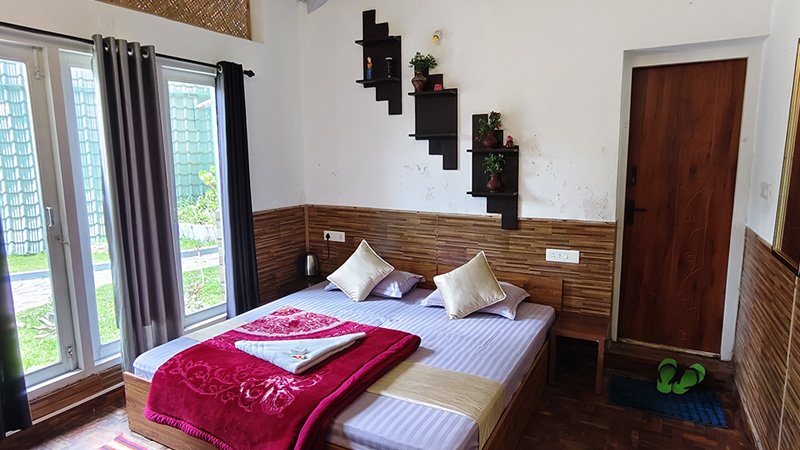Cozy bedroom with large glass doors, wooden wall paneling and modern interior decor