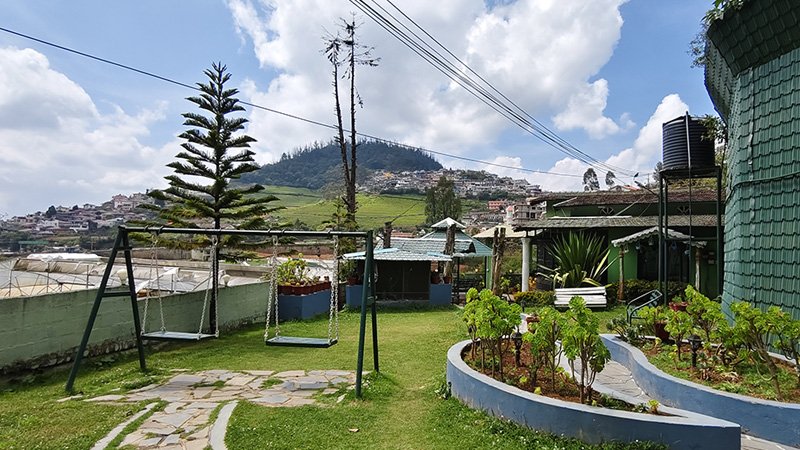 Garden area with outdoor swing seating, landscaped lawn and scenic mountain view surroundings