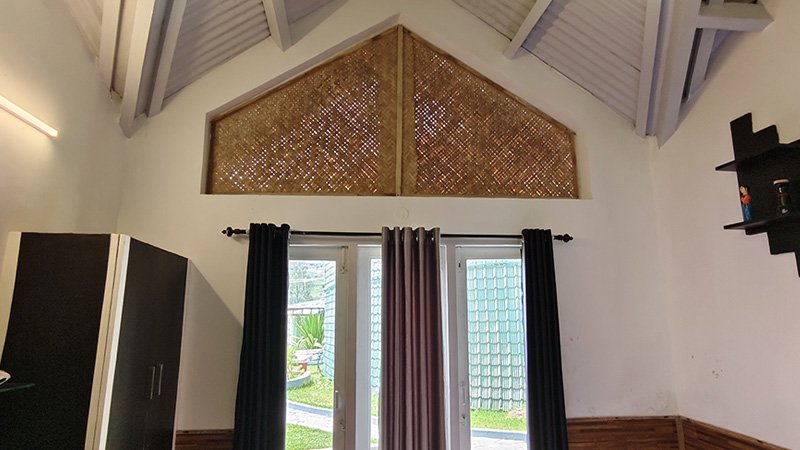 High ceiling bedroom interior with large glass doors, ventilation panel and natural light entry