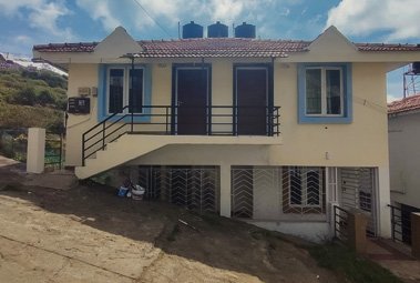 Cottage with balcony, tiled roof and front entrance