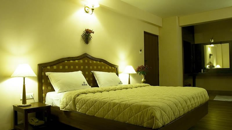 Double bedroom with wooden bed, bedside lamps and warm interior lighting