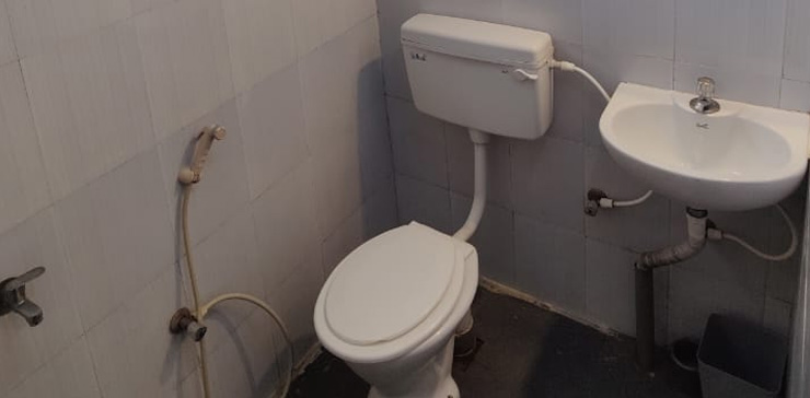 Clean attached bathroom with toilet and wash basin