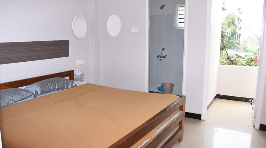 Cottage bedroom with balcony view and ensuite bathroom