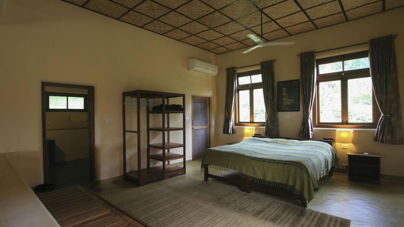 Spacious bedroom with double bed, large windows, air conditioning and wooden furnishings