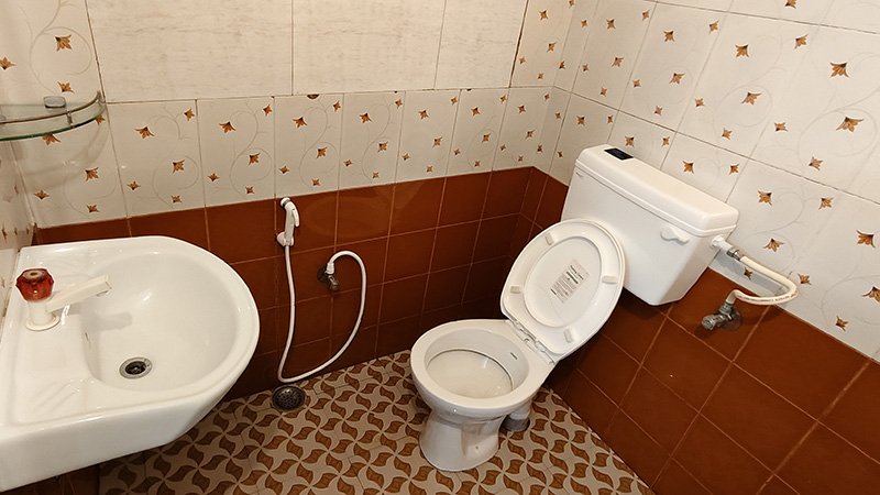 Bathroom with toilet, sink and tiled walls