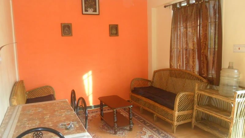 Living and dining area with wicker sofa, chairs, table and warm interior decor