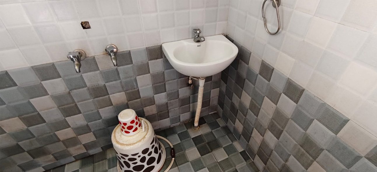 Bathroom with a wall-mounted wash basin and tiled walls