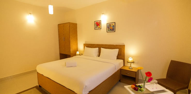 Elegant cottage room interior featuring a comfortable double bed, bedside lamps, modern decor, and minimalist design