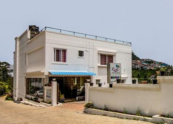 Rich White House Cottage exterior with parking space and hillside backdrop