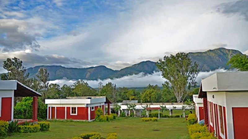 Holiday homes with green lawns overlooking mist-covered mountain ranges