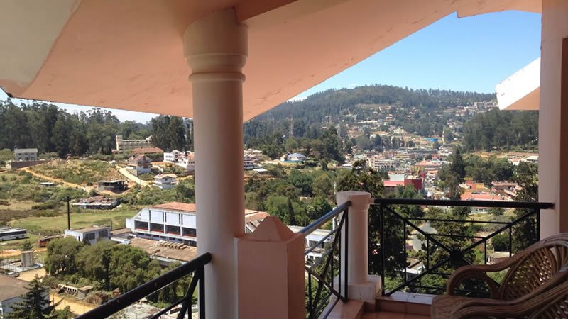 Balcony with town and hill view