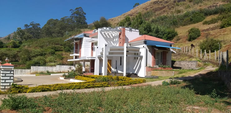 Exterior view of a cottage surrounded by mountains at Toy Cottage