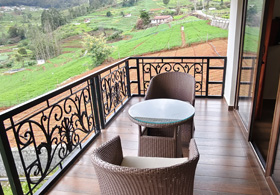 Private balcony of an Ooty cottage offering peaceful valley and hillside views, perfect for relaxation