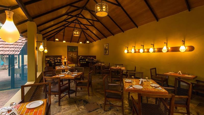 Cottage restaurant with wooden dining tables, warm lighting and high ceiling