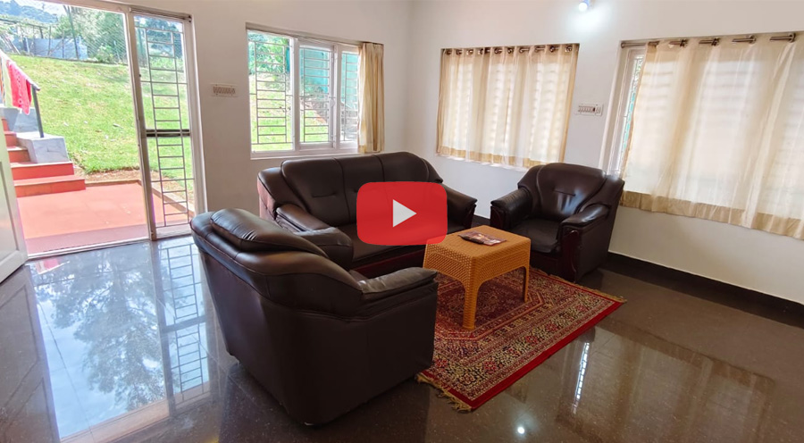 Bright cottage living room with brown leather sofa set and large windows